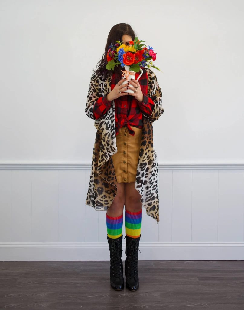 Youth holding rainbow flowers